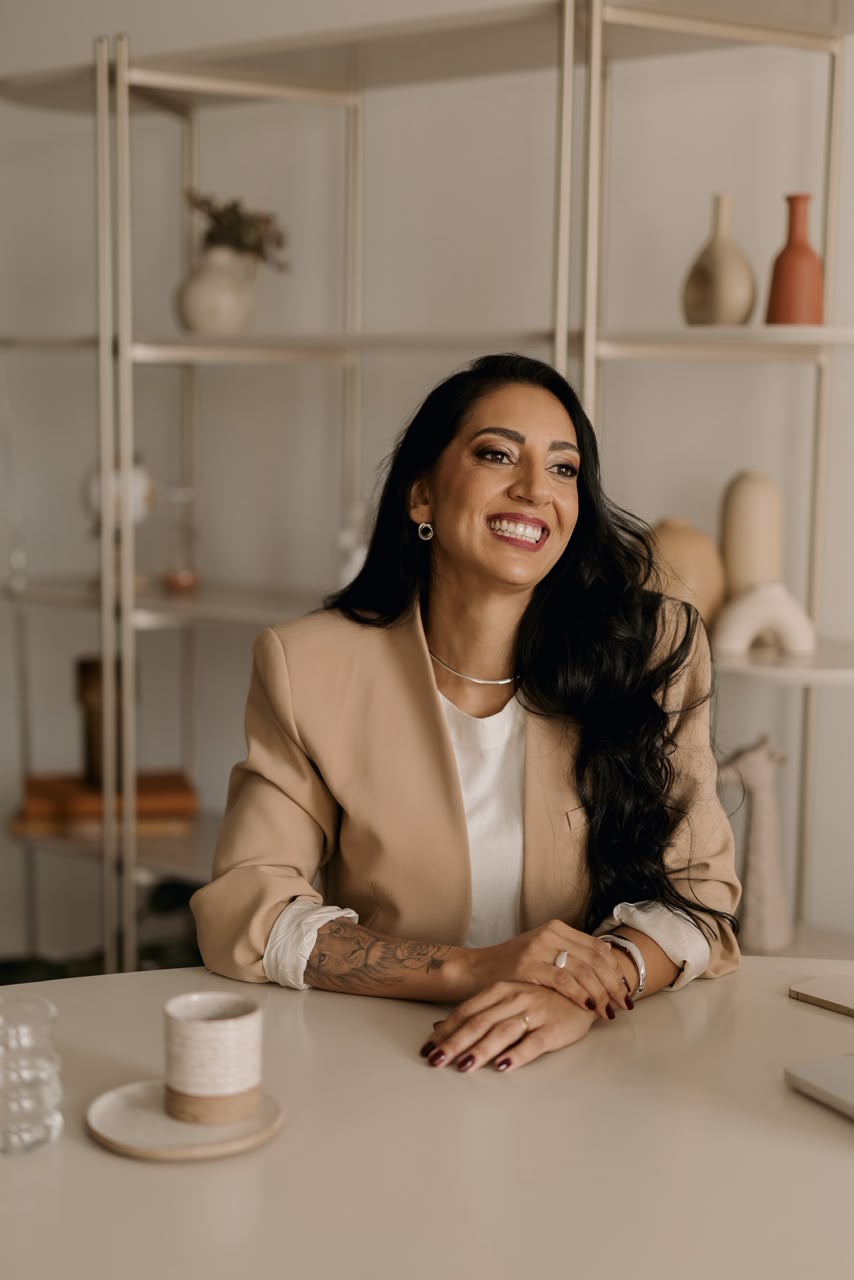 Valesca Tessidor, fundadora da Melhor Forma, sentada à mesa em um ambiente acolhedor